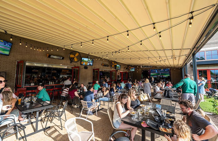Game day at Roswell Junction sports bar — front patio with TVs and crowd